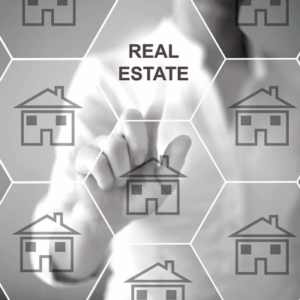 Hand touching a digital interface with house icons and the words "REAL ESTATE".